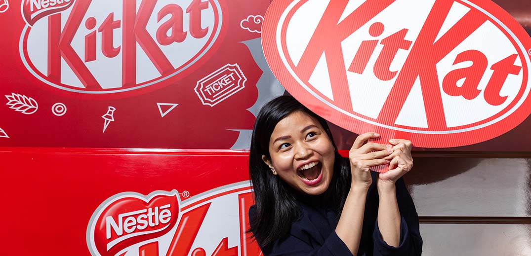 woman holding kitkat sign
